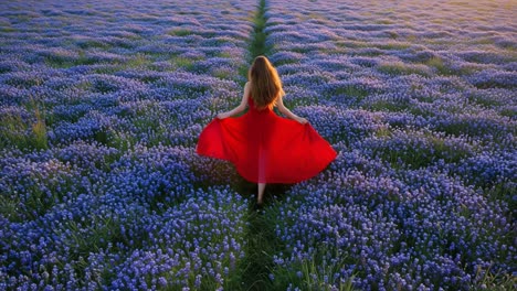 woman in red dress walking through a field of purple flowers