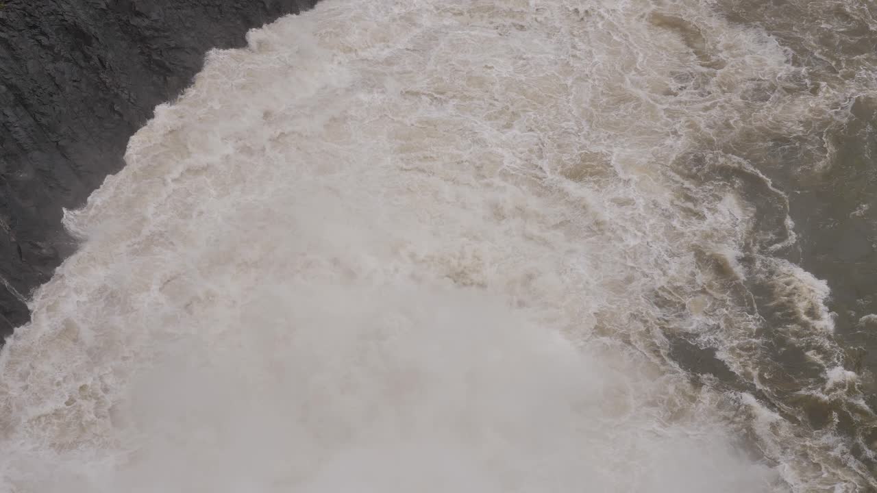 Handheld shot of Hinze Dam turbulent outflows under heavy rain during La Ni&ntilde;a, Gold Coast Hinterland, Queensland, Australia