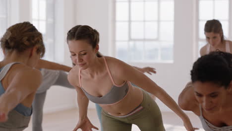 Hermosa-Mujer-De-Yoga-Practicando-Pose-De-Guerrero-En-El-Gimnasio-Entrenamiento-Femenino-Caucásico-Con-Un-Grupo-De-Instructores-De-Mujeres-Disfrutando-De-Un-Estilo-De-Vida-Saludable-Y-Equilibrado