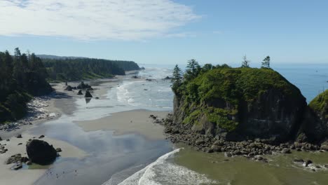 Drone-Flies-Close-to-Trees-and-Rocks-on-Coastal-Beach-on-Summer-Afternoon-Day