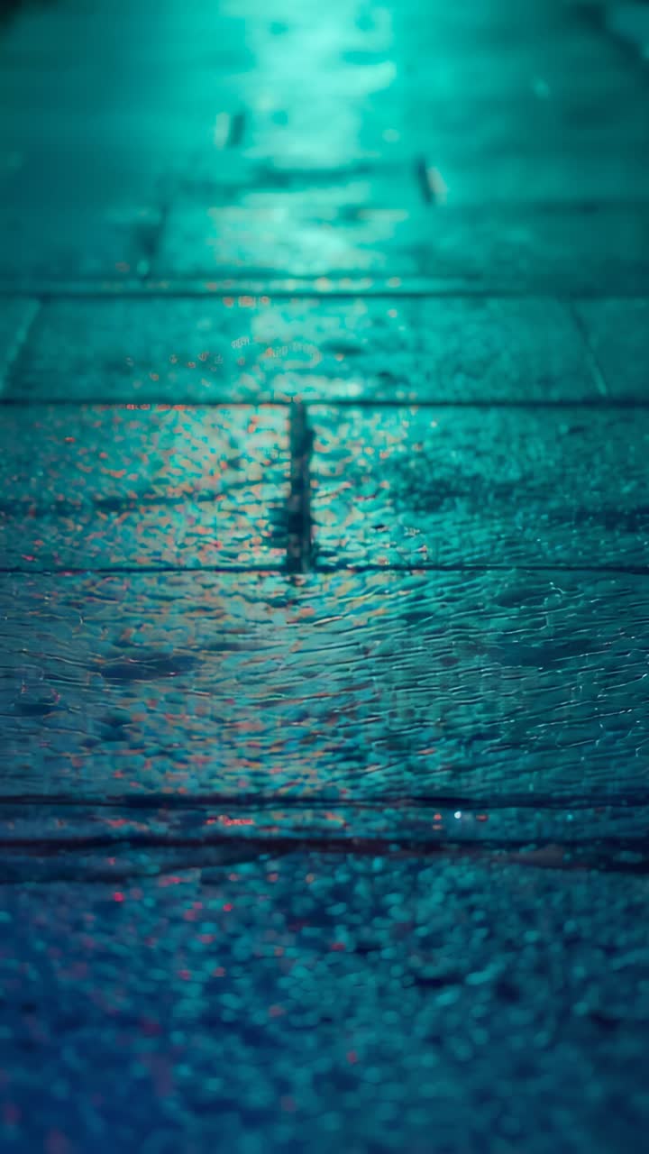 Vertical video: Moving lens in revealing wet grout on sidewalk at night, showing neon contrast