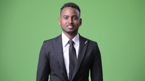 young handsome african businessman against green background