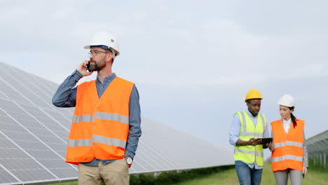 ingeniero jefe hablando por teléfono mientras está de pie en una plantación solar