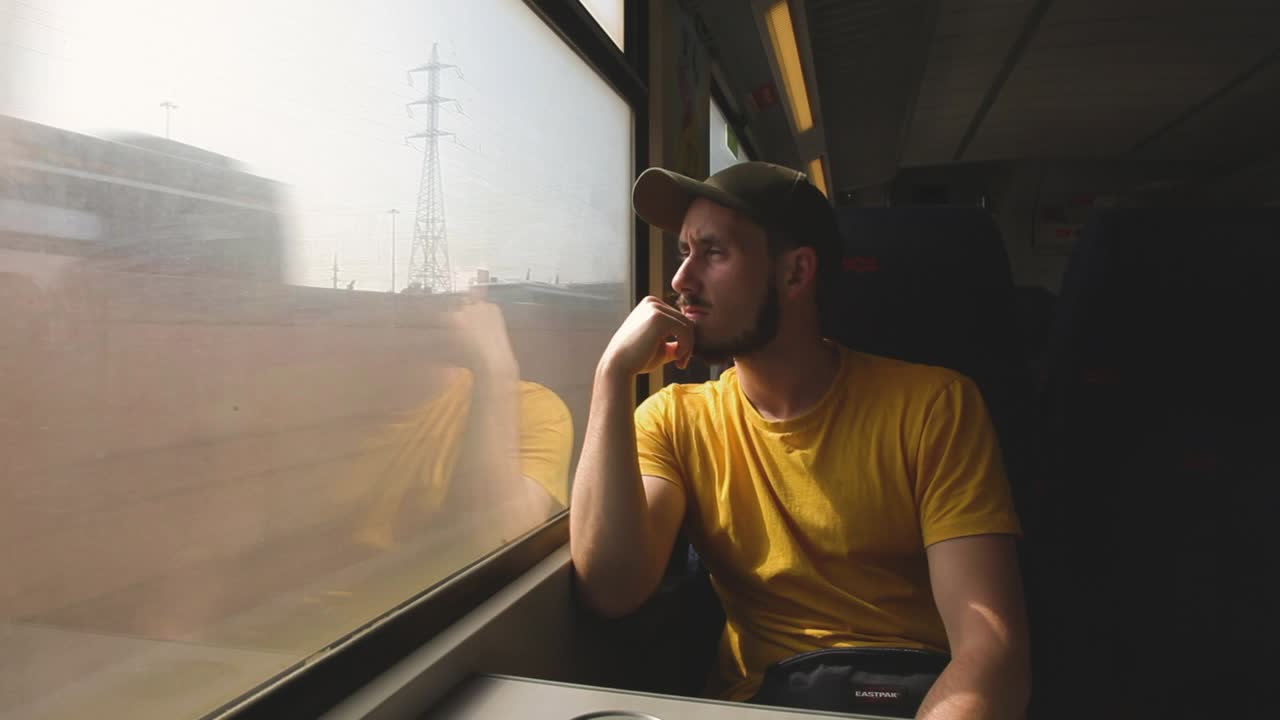 Turista europeo seduto su un treno locale, Tel Aviv, Israele, inquadratura grandangolare.