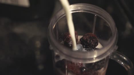 adding the milk in the blender jar with dried fruits