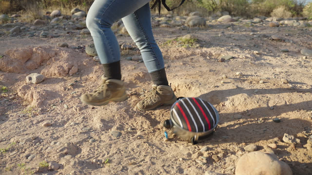 하이커는  ⁇ 과 바위에서 사막 하이킹에 캠핑 캔틴을 떨어 ⁇ 니다.