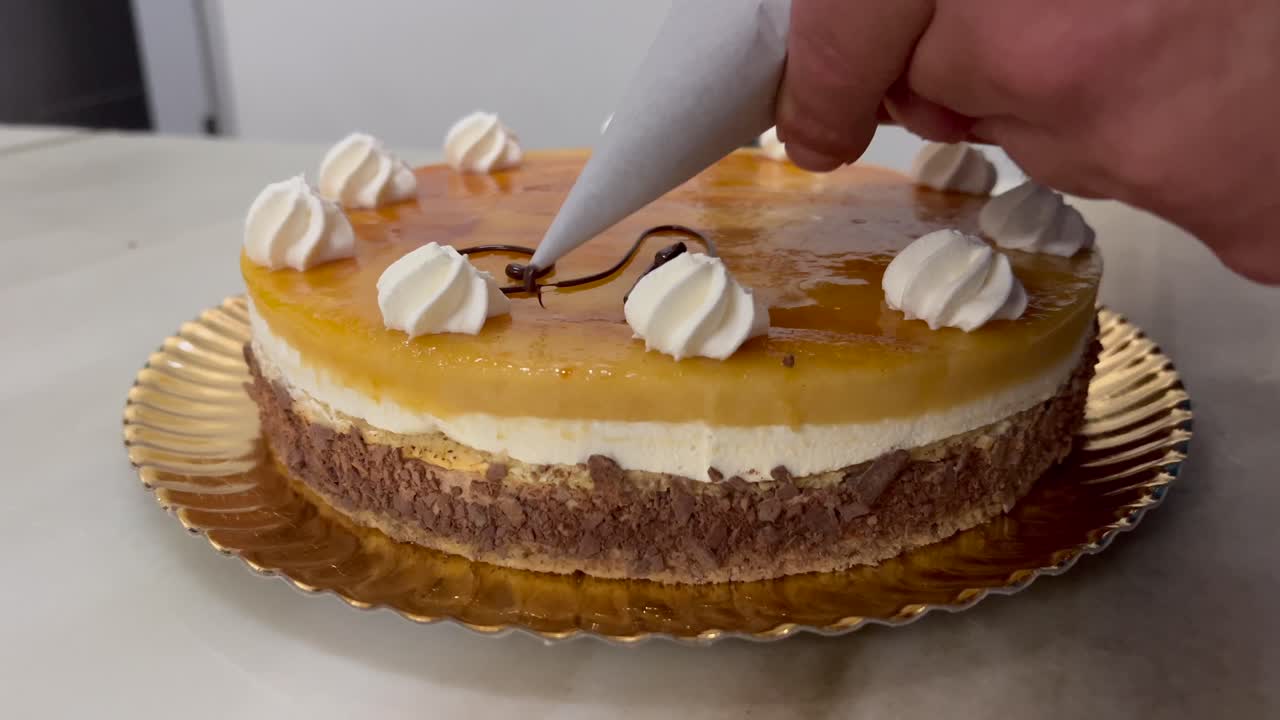 Mano di un pasticcere che decora una torta di compleanno con cioccolato fuso.