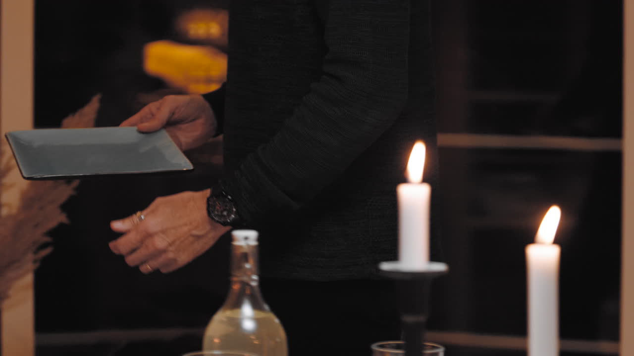 viejo anciano chico abuelo abuelo poner mesa colocar platos con tenedores cuchara cuchillos cenar preparar comida con amigos reunión europea festiva casa de vacaciones feliz delicioso