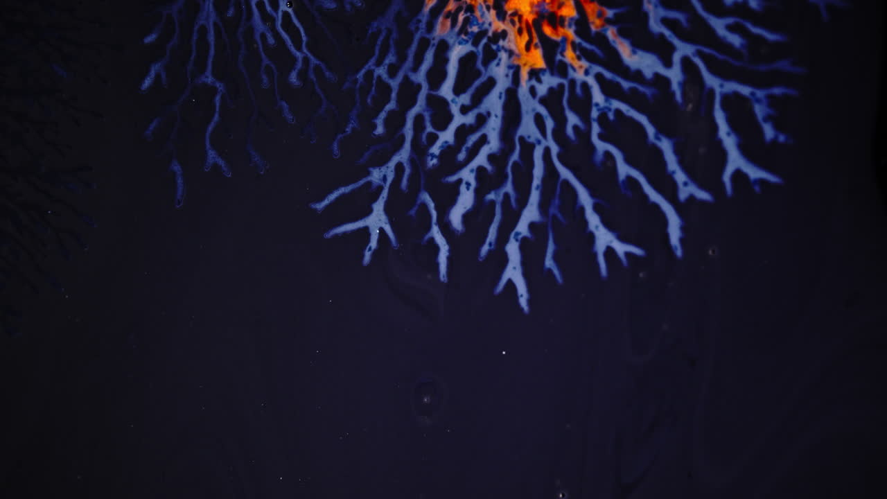 Abstract macro shot of ink patterns branching like veins, vivid purple and orange colors