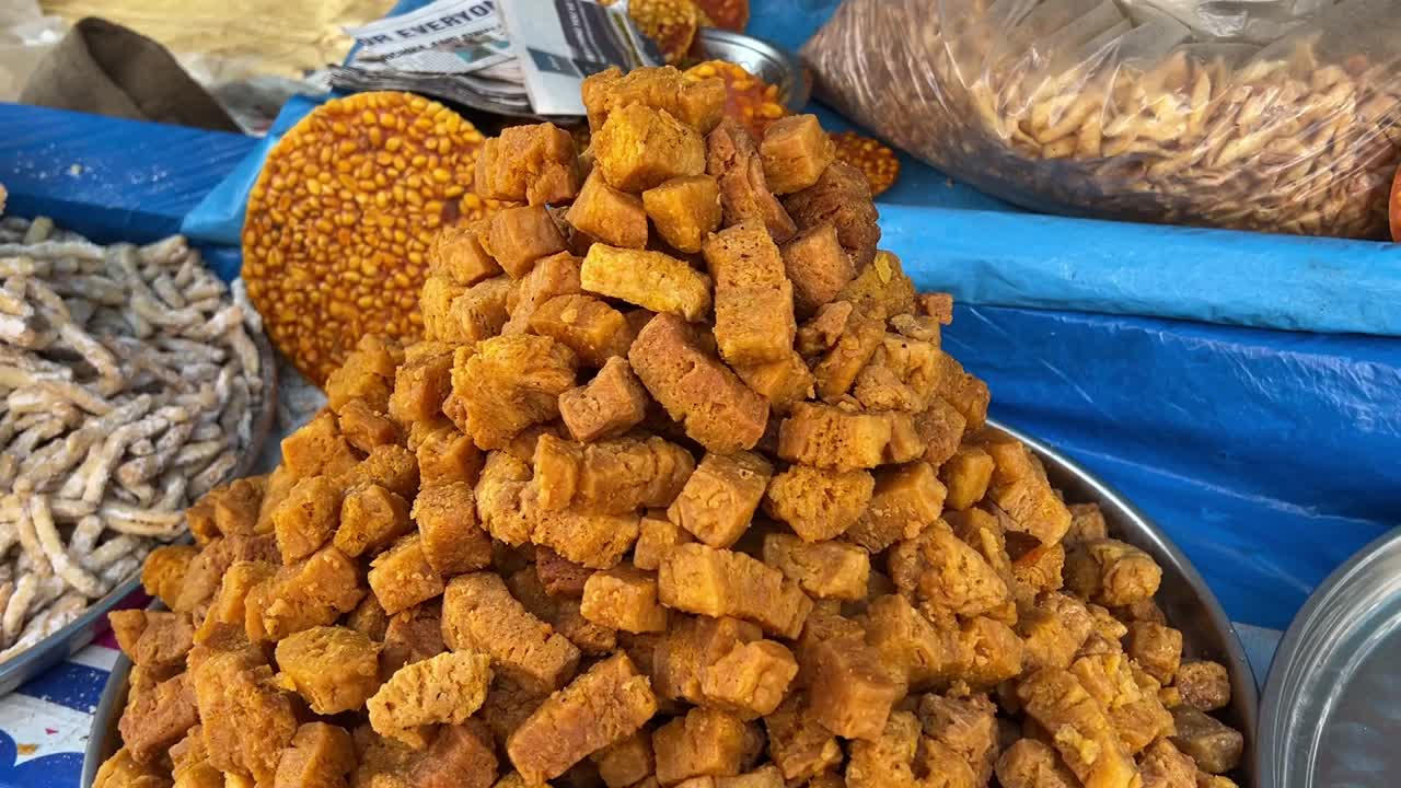 fotografía giratoria de deliciosos dulces fritos tradicionales en exhibición en un puesto en la carretera en un frío día de invierno en calcuta, india