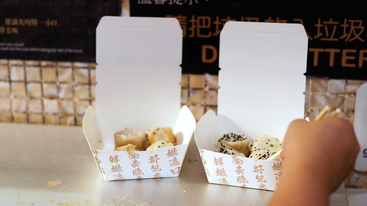 palillos para comer recogiendo panes de una caja de comida para llevar