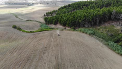 disparando con un dron un tractor trabajando un campo en el campo de puglia