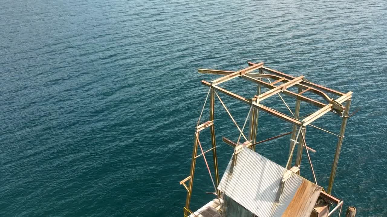 viejo muelle abandonado en un lago con jet ski en segundo plano.