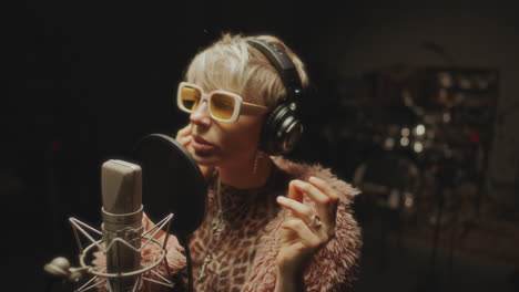 female music artist recording vocals in professional studio