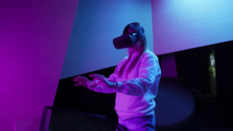 girl in a virtual reality headset making hand gestures in the air, handheld shot