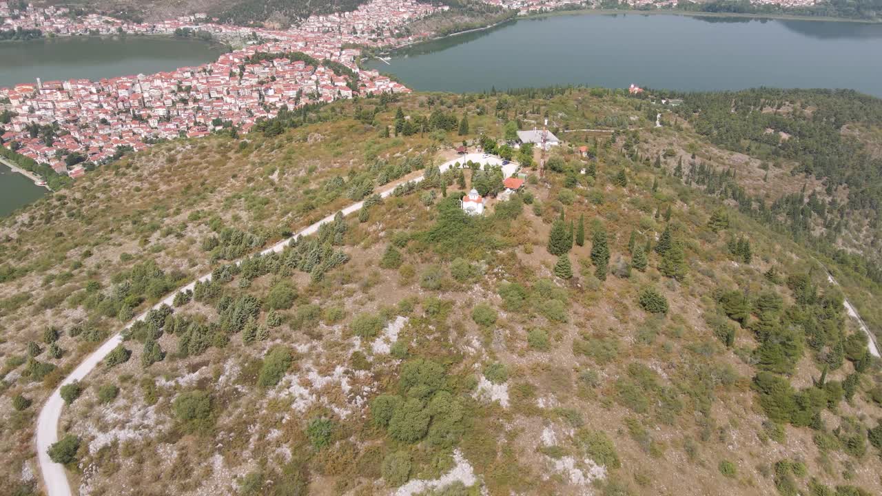 clip aéreo sobre una montaña que revela la ciudad y el lago de kastoria, en el norte de grecia