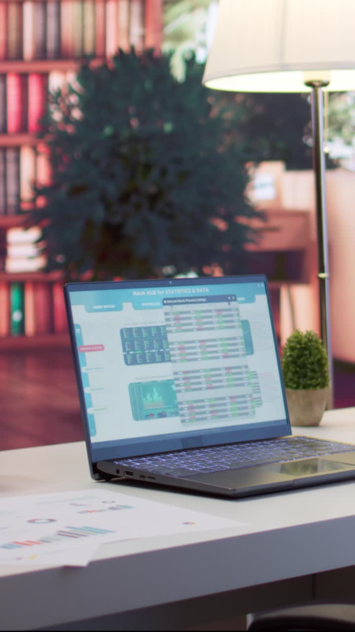 Laptop Displaying Financial Statistics and Data on Office Desk