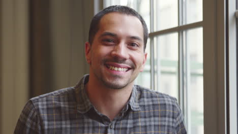 Casually-dressed-Hispanic-businessman-smiling-to-camera