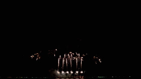 luces coloridas estallando en el cielo nocturno una tras otra para una exhibición de pirotecnia en un festival internacional de fuegos artificiales en el sudeste asiático