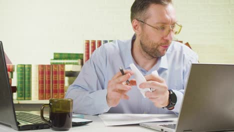 el hombre en la oficina revisa los informes fiscales, los documentos y los formularios, encuentra un error crítico, arrugó el papel enojadamente y lo arrojó