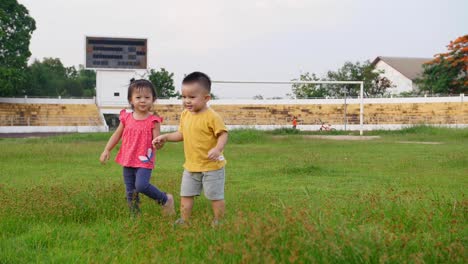 little boy and little girl holding hand and walking together