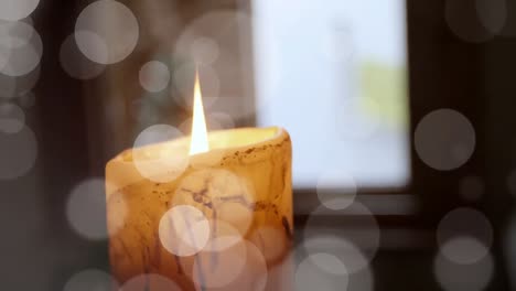 Animation-of-white-light-spots-over-lit-candle