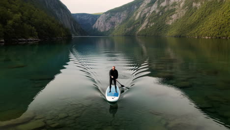 stand-up paddleboarding on a tranquil lake surrounded by mountains