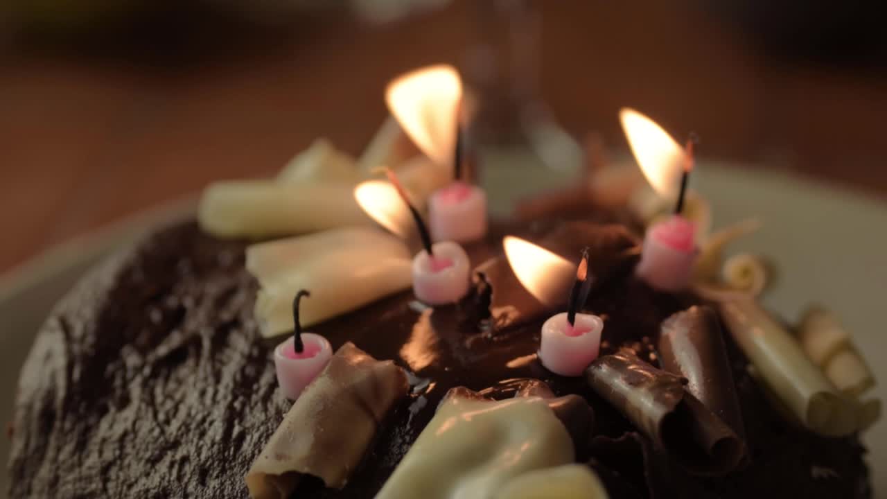 pastel de cumpleaños de chocolate con velas parpadeantes primer plano