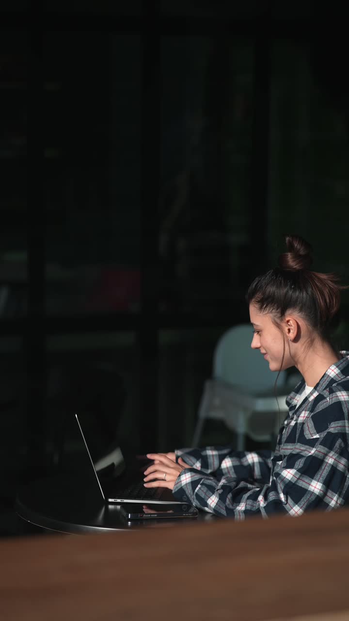 mujer trabajando en una computadora portátil en un café