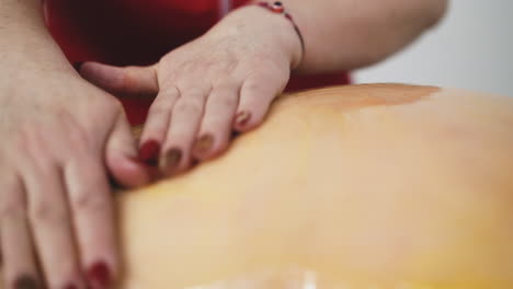 woman doctor spreads honey on client back to do massage