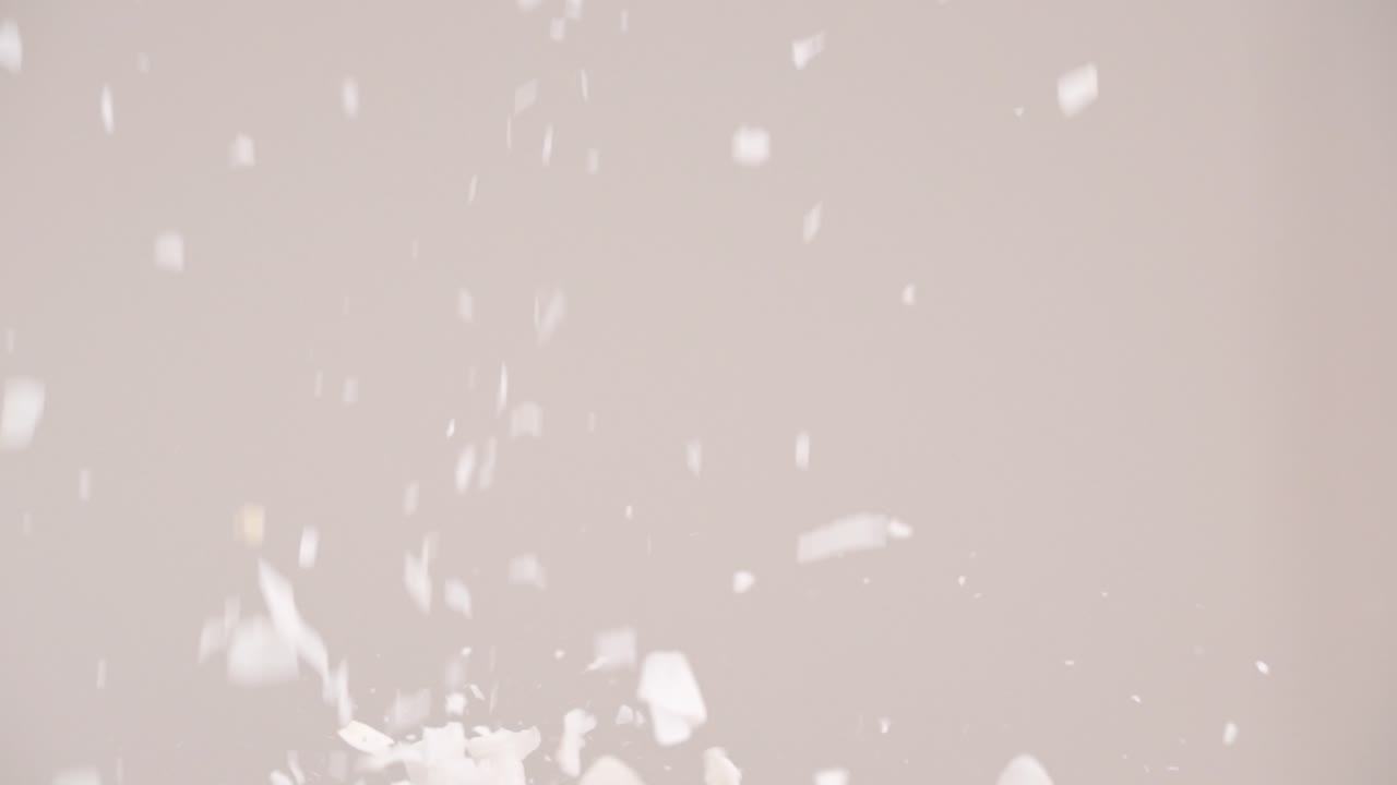 코코넛 조각이 비가 내리고 회색 배경 4k로 슬로우 모션으로 튀는