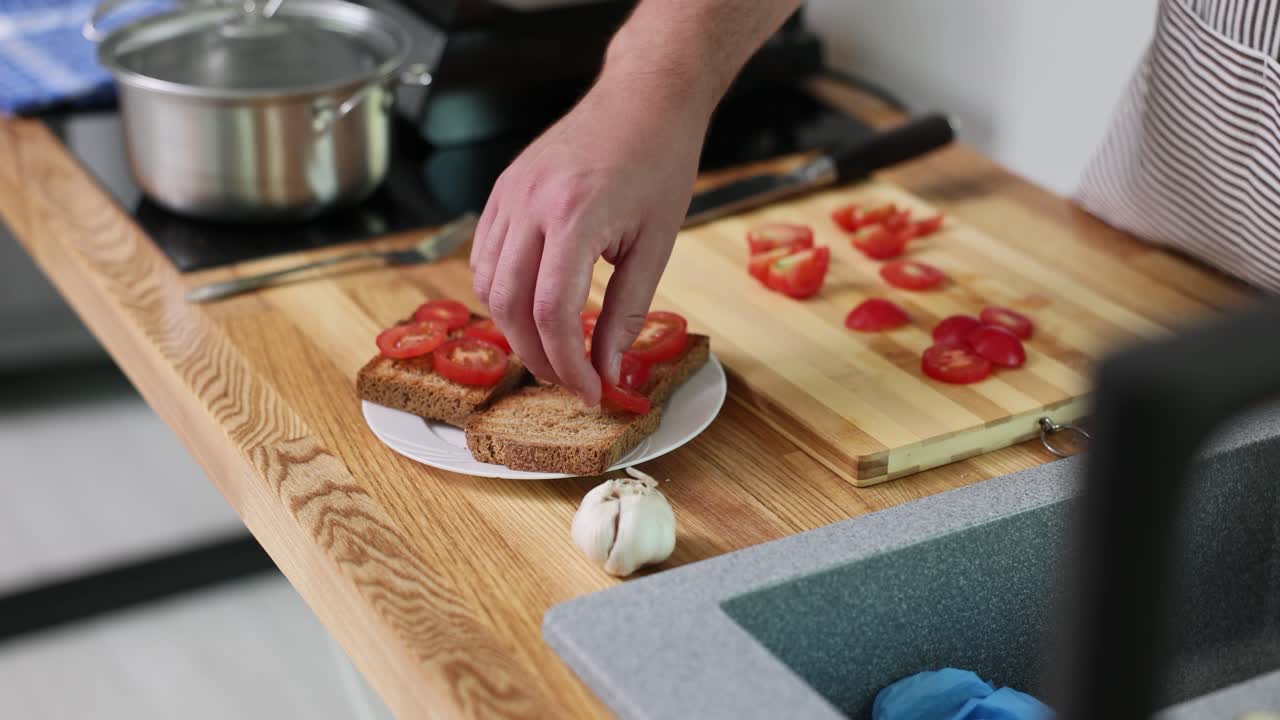 Person preparing tomato toast in a kitchen