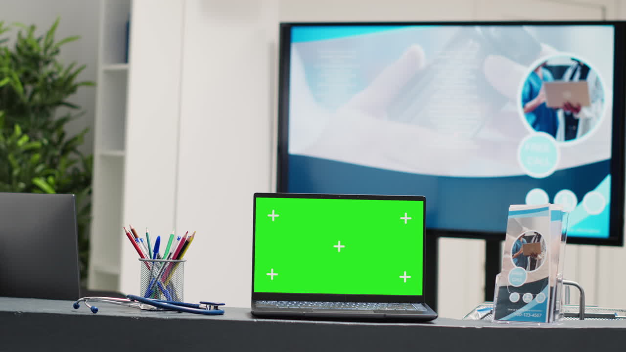 Laptop with greenscreen display at desk