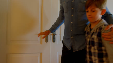 Rear-view-of-Caucasian-boy-greeting-his-father-at-the-door-in-a-comfortable-home-4k