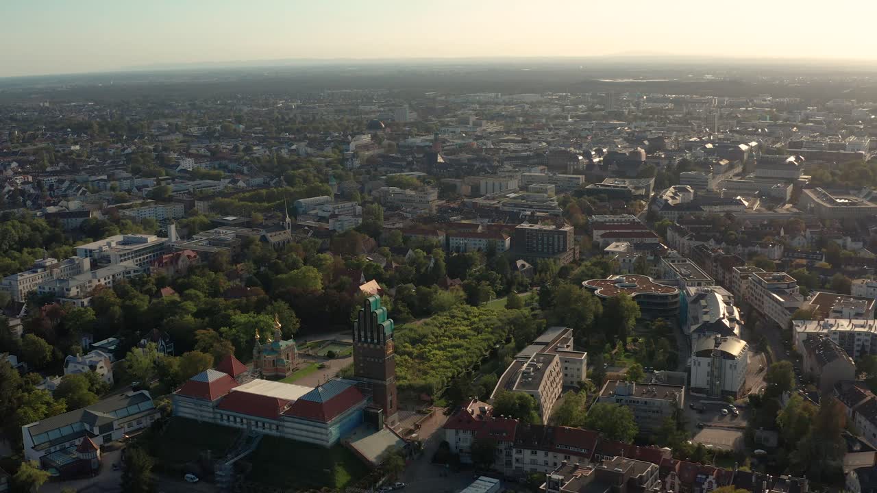 acercándose a darmstadt con el mathildenhoehe con el centro de la ciudad al fondo con un dron en un día soleado de verano