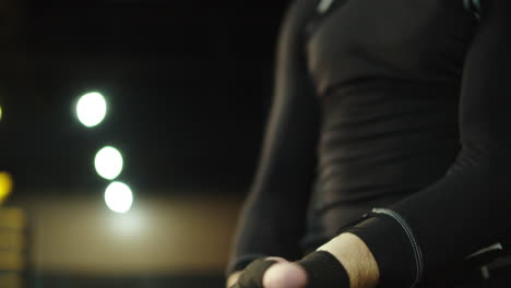 male person wrapping hands in fitness center. boxer ready to wear boxing gloves