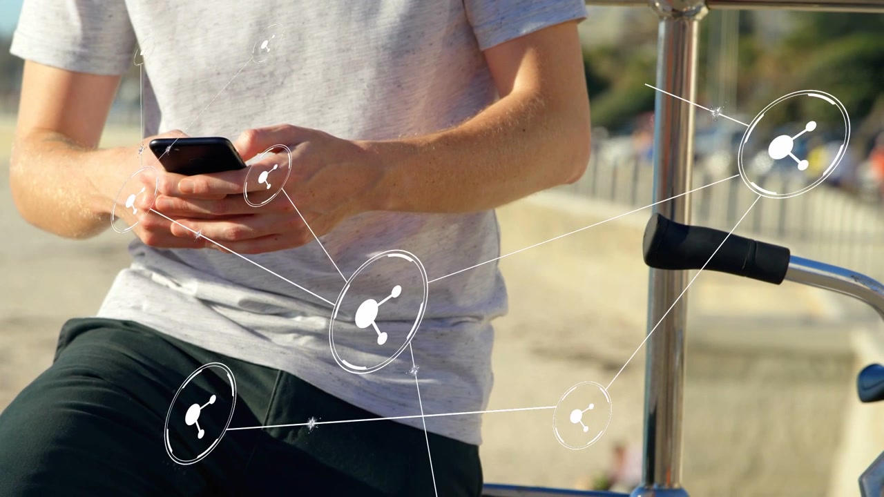 Uomo che tocca lo smartphone e genera nodi di rete tecnologici che si collegano attraverso la riva della spiaggia verso i binari.