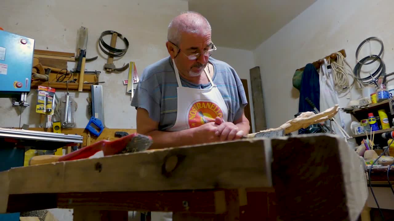 Italian Sculptor in his workshop working on a olive wood statue