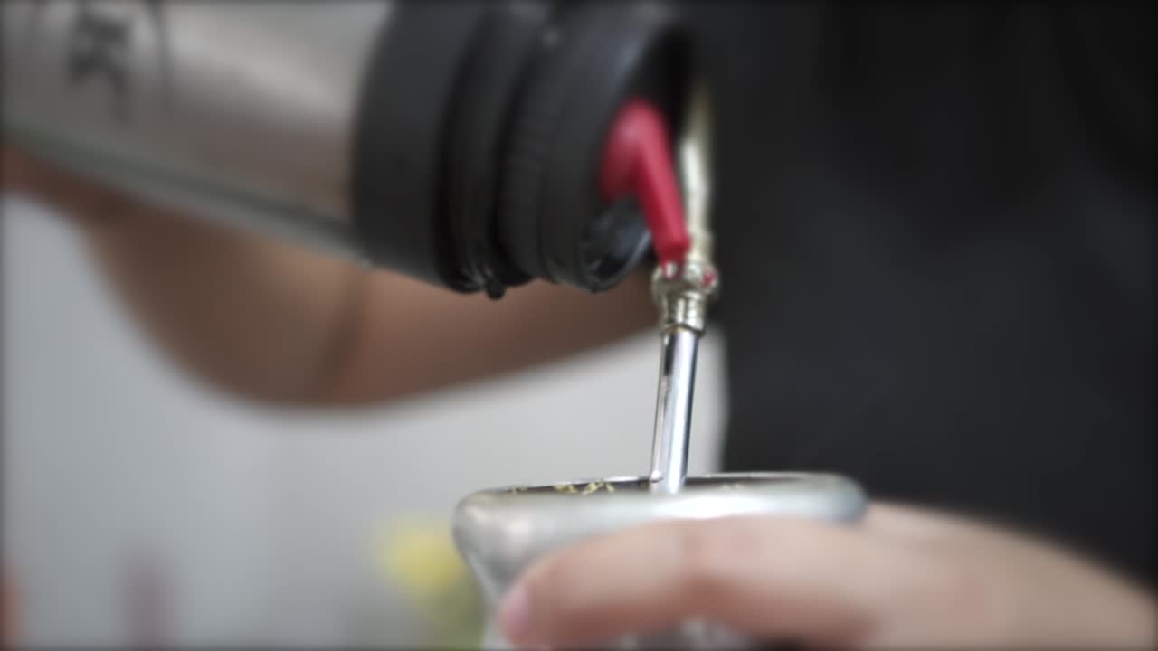 Steaming hot water being gracefully poured into a mate gourd, setting the stage for the traditional South American ritual