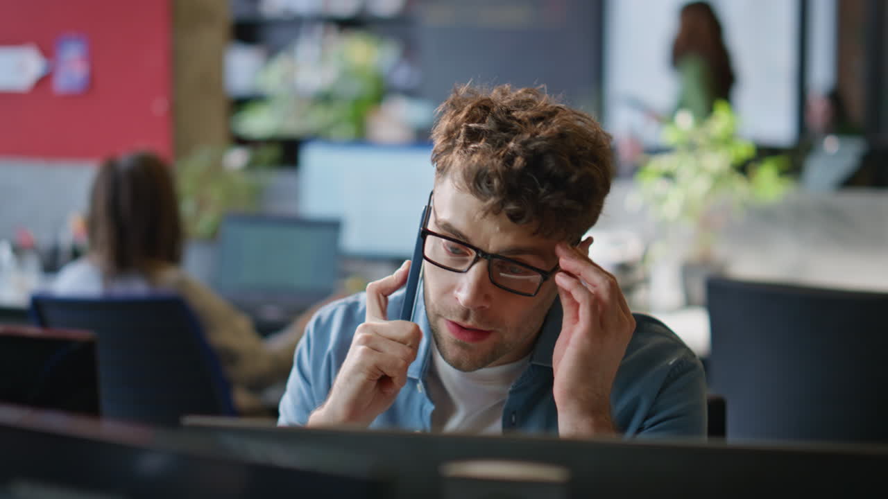 Sales professional speaking mobile phone client at contemporary office closeup