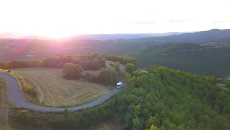 aerial panoramic drone view of a big motorhome driving throng a lonely and wild road in the mountains of spain. 4k footage.