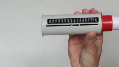 man using pef asthma test to measure air flowing out of lungs, peak flow rate