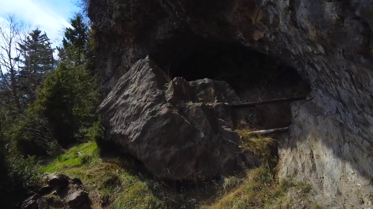 Ripresa aerea che avanza e arretra verso l'oscura grotta dell'orso, tra le montagne e la foresta di Lizara, nei Pirenei spagnoli