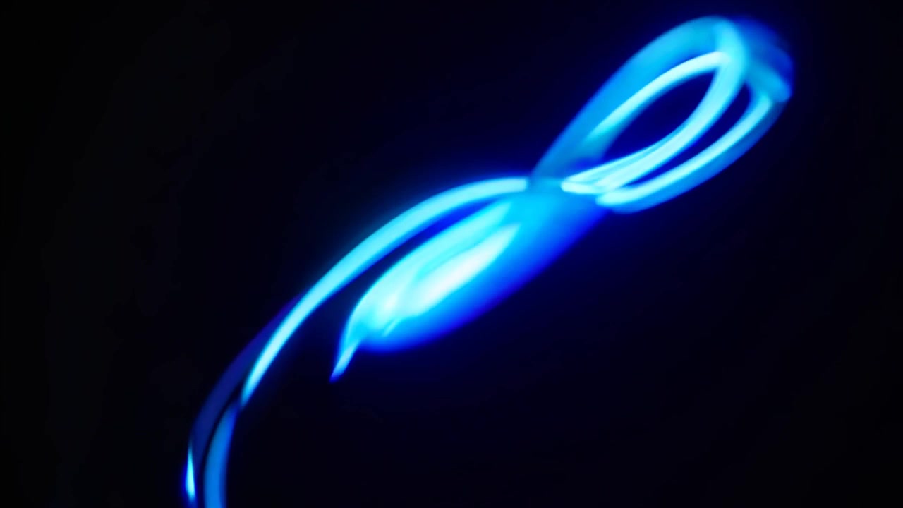 Abstract Blue Light Trails Moving Against Black Background