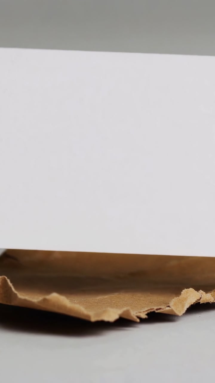 Blank White Paper Sliding Over Crumpled Brown Sheet