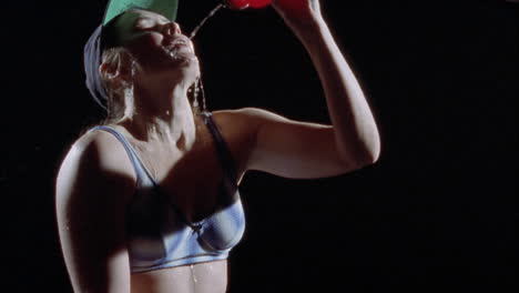 una mujer vierte agua sobre su cara