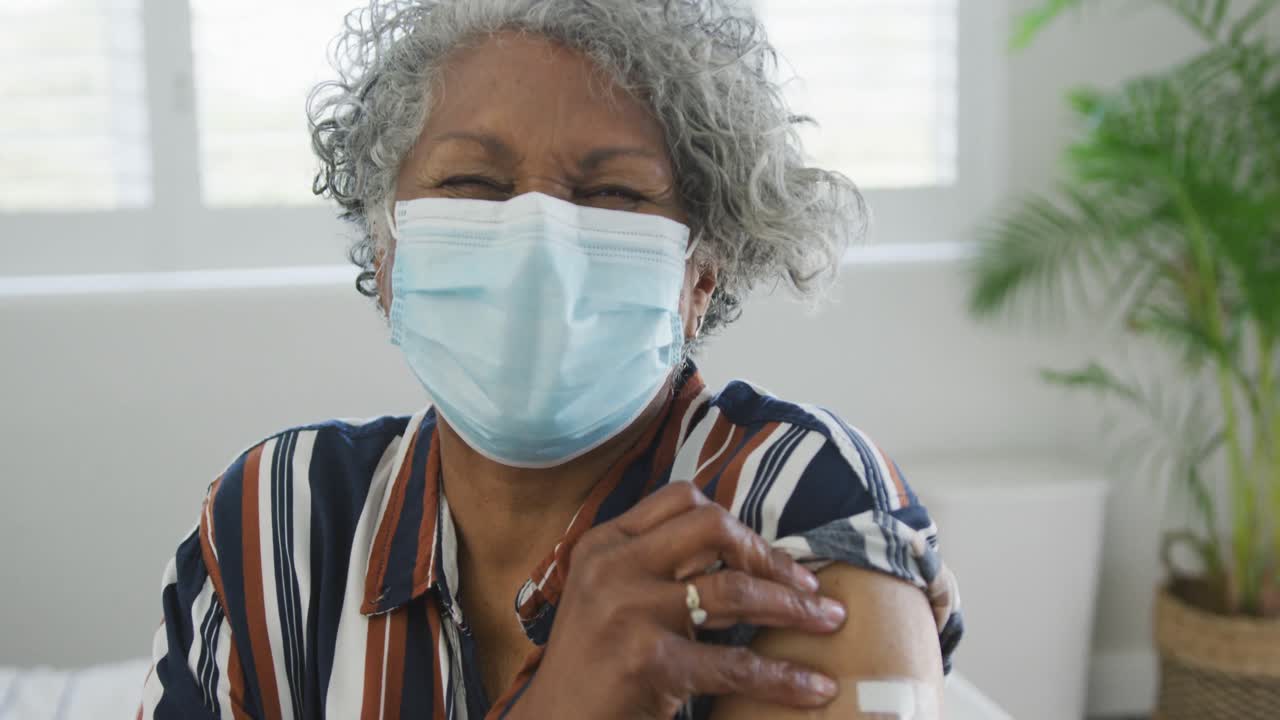 African american senior woman wearing face mask with plaster after vaccination