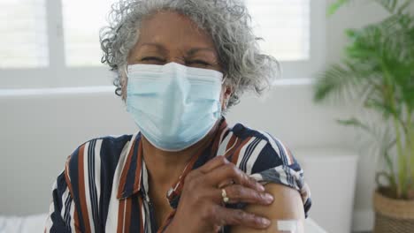 African-american-senior-woman-wearing-face-mask-with-plaster-after-vaccination