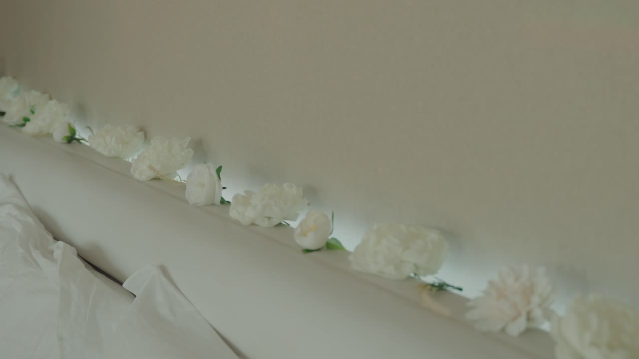 close up of white floral arrangement along headboard creating elegant serene mood