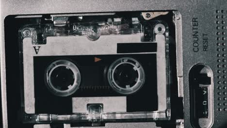 the microcassette spins in a portable handheld recorder, tape retro player